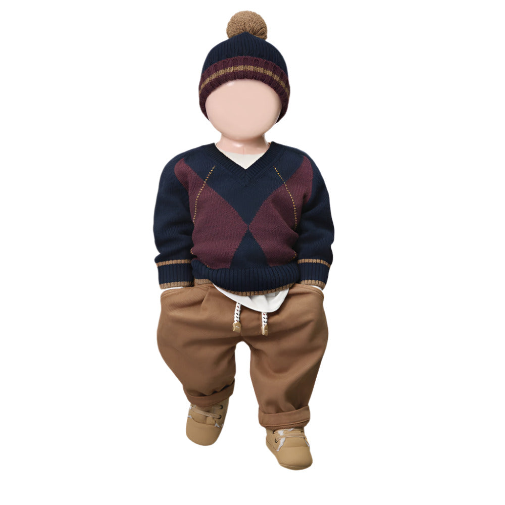 Child's outfit with a navy sweater, brown pants, and a knit hat on a white background