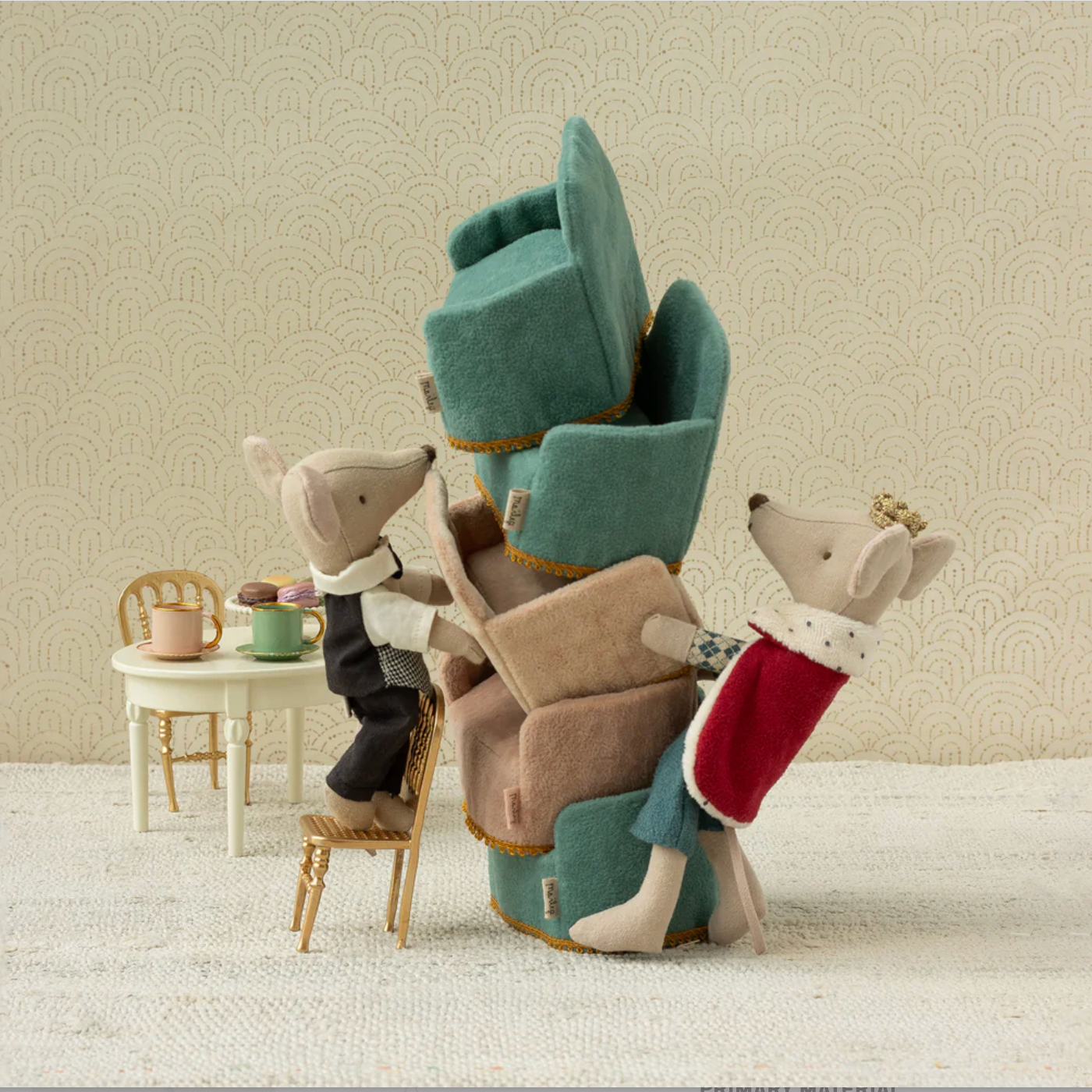 Stacked plush chairs with decorative animals on a neutral background