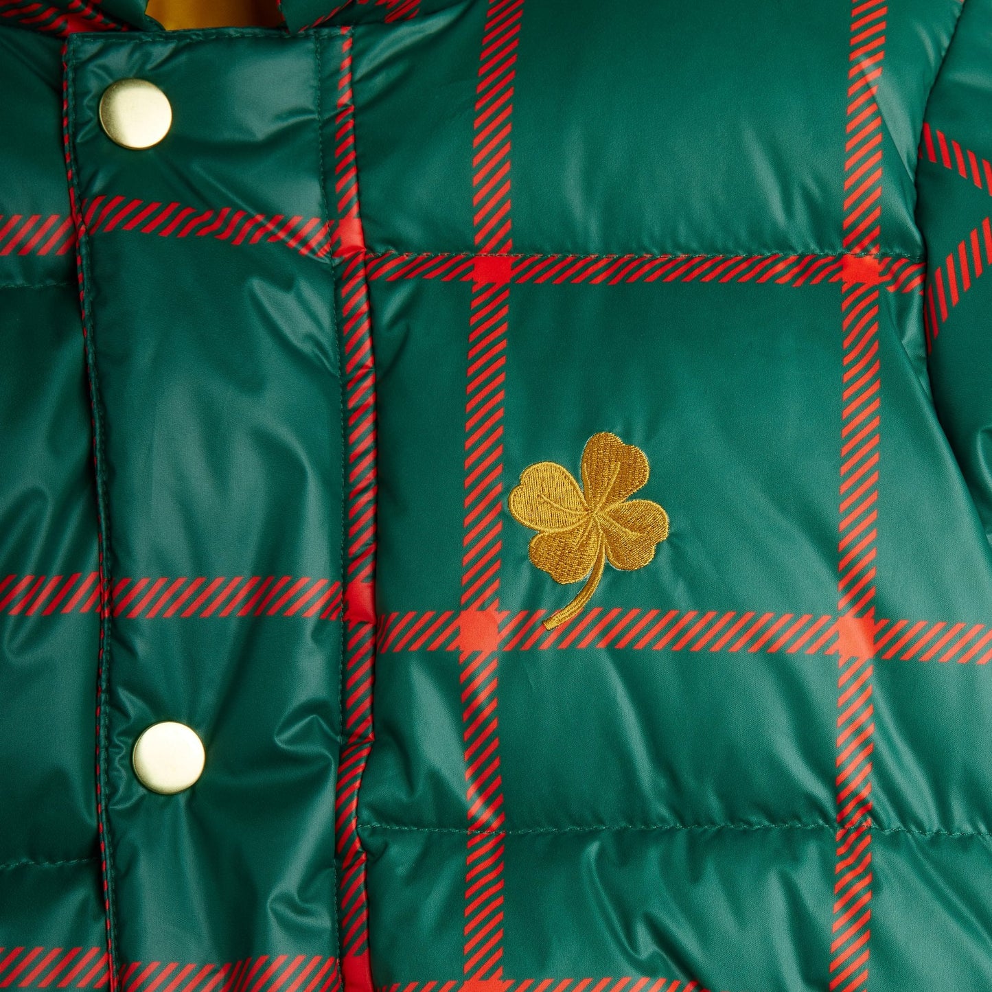 Green plaid jacket with a gold four-leaf clover emblem