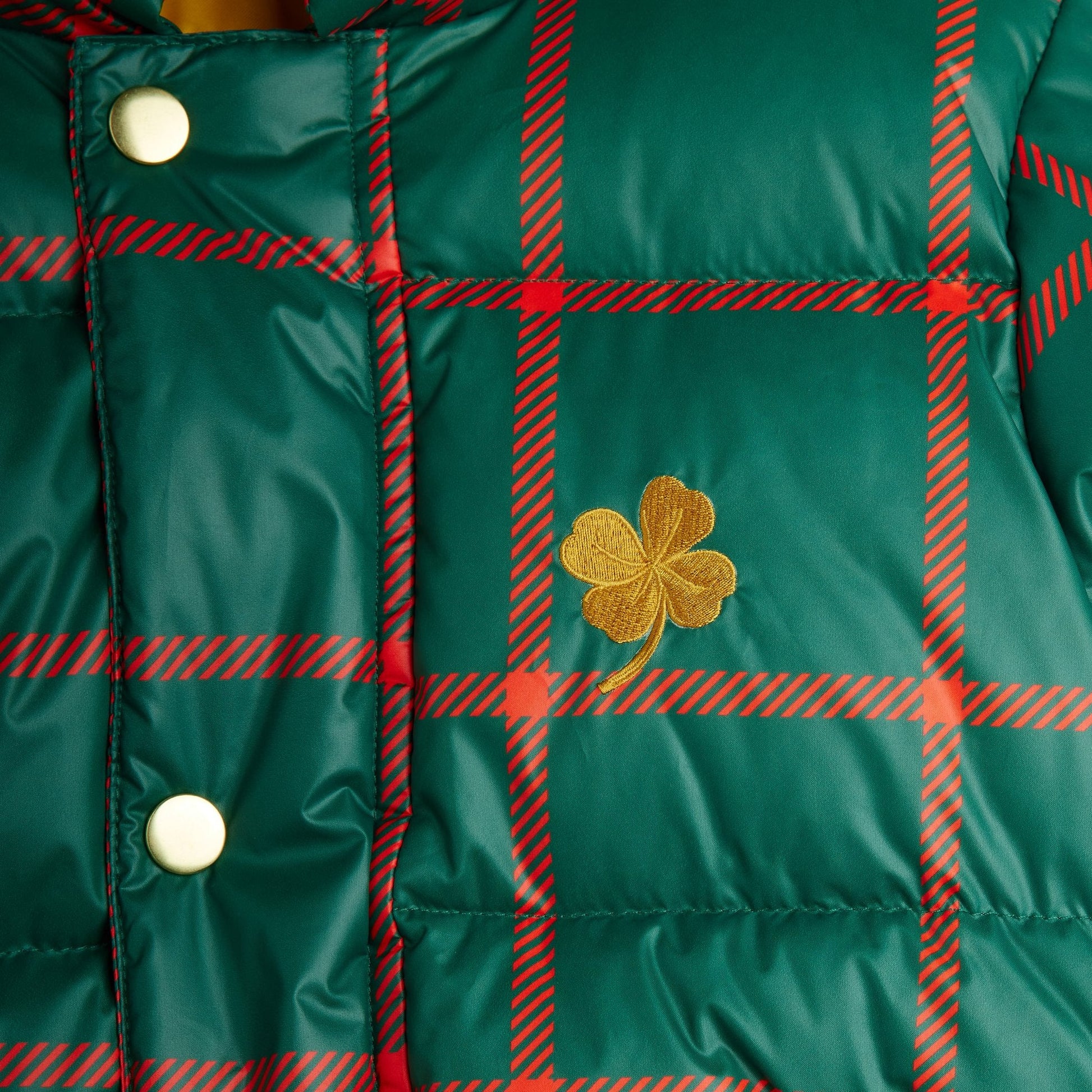 Green plaid jacket with a gold four-leaf clover emblem
