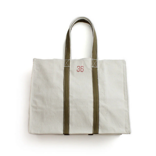 White tote bag with green straps on a white background