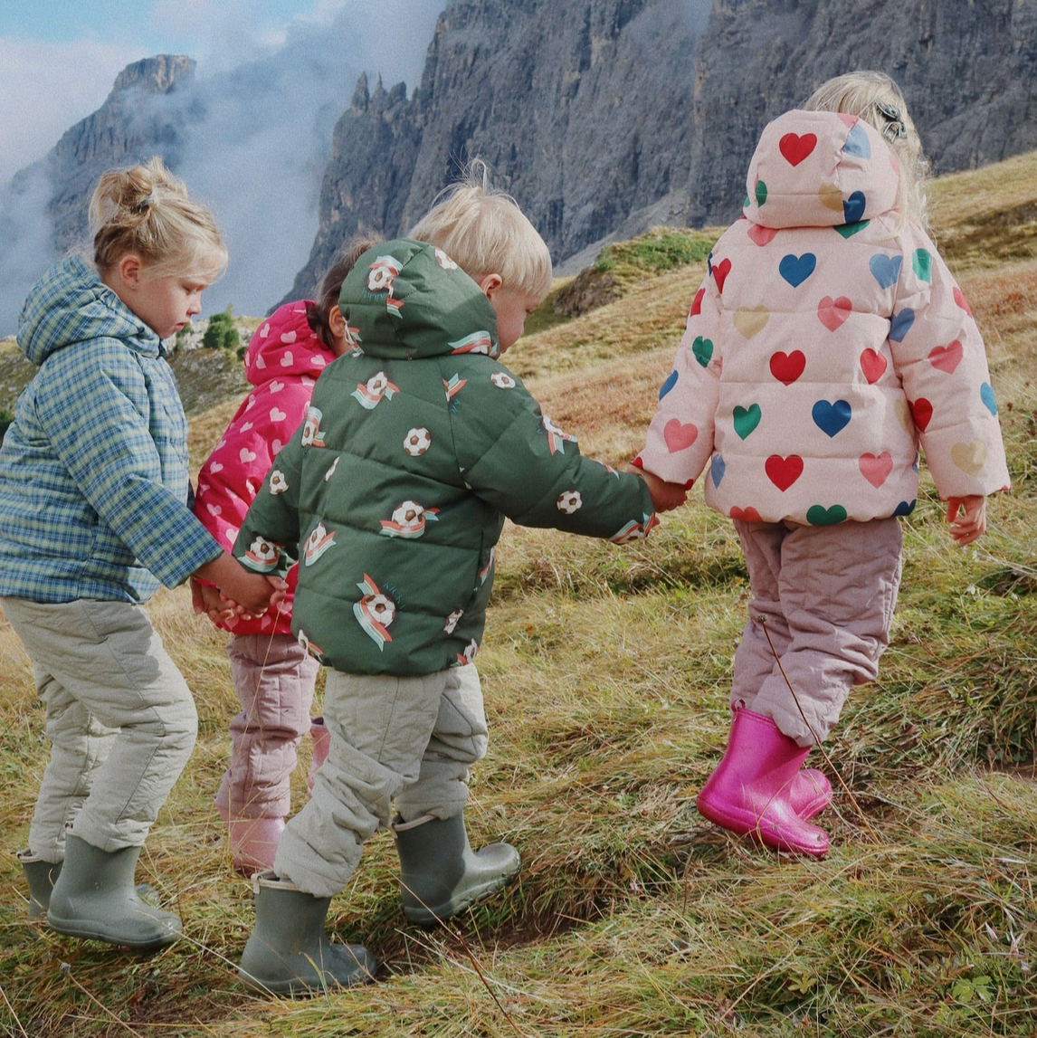 Children holding hands in a mountainous landscape