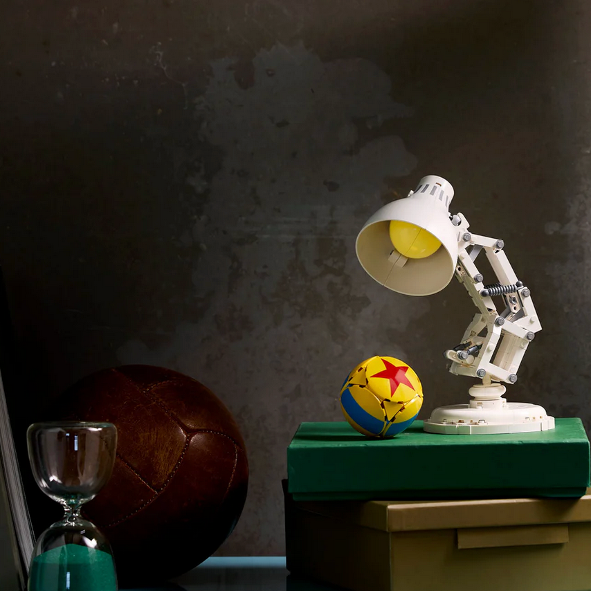 Desk lamp with adjustable arm on a green surface against a dark background