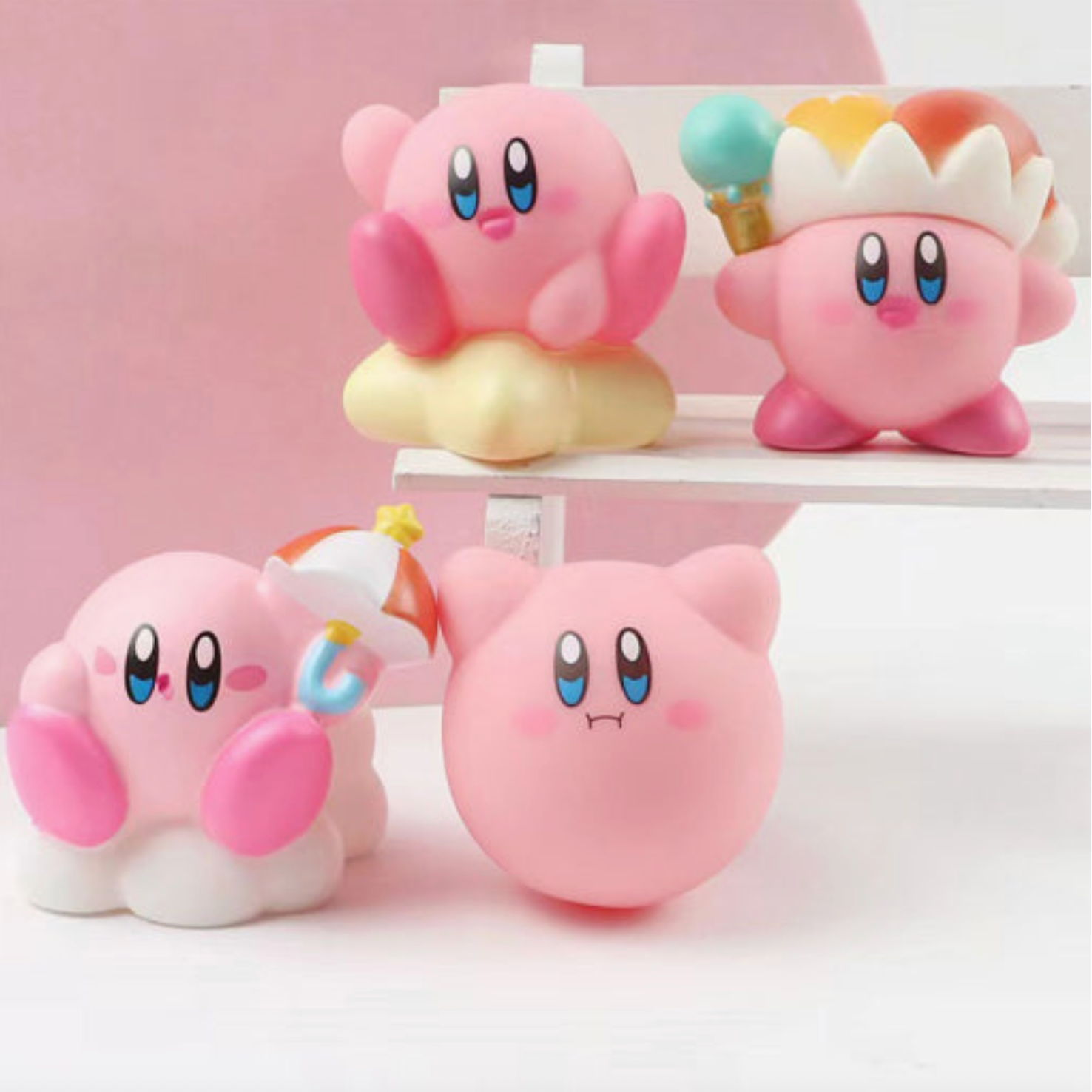 Four pink cartoon characters with blue eyes and colorful hats on a white shelf against a pink background