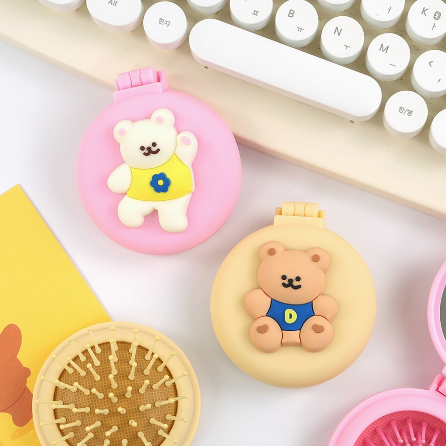 Two small round containers with bear designs on a white surface with a keyboard in the background.