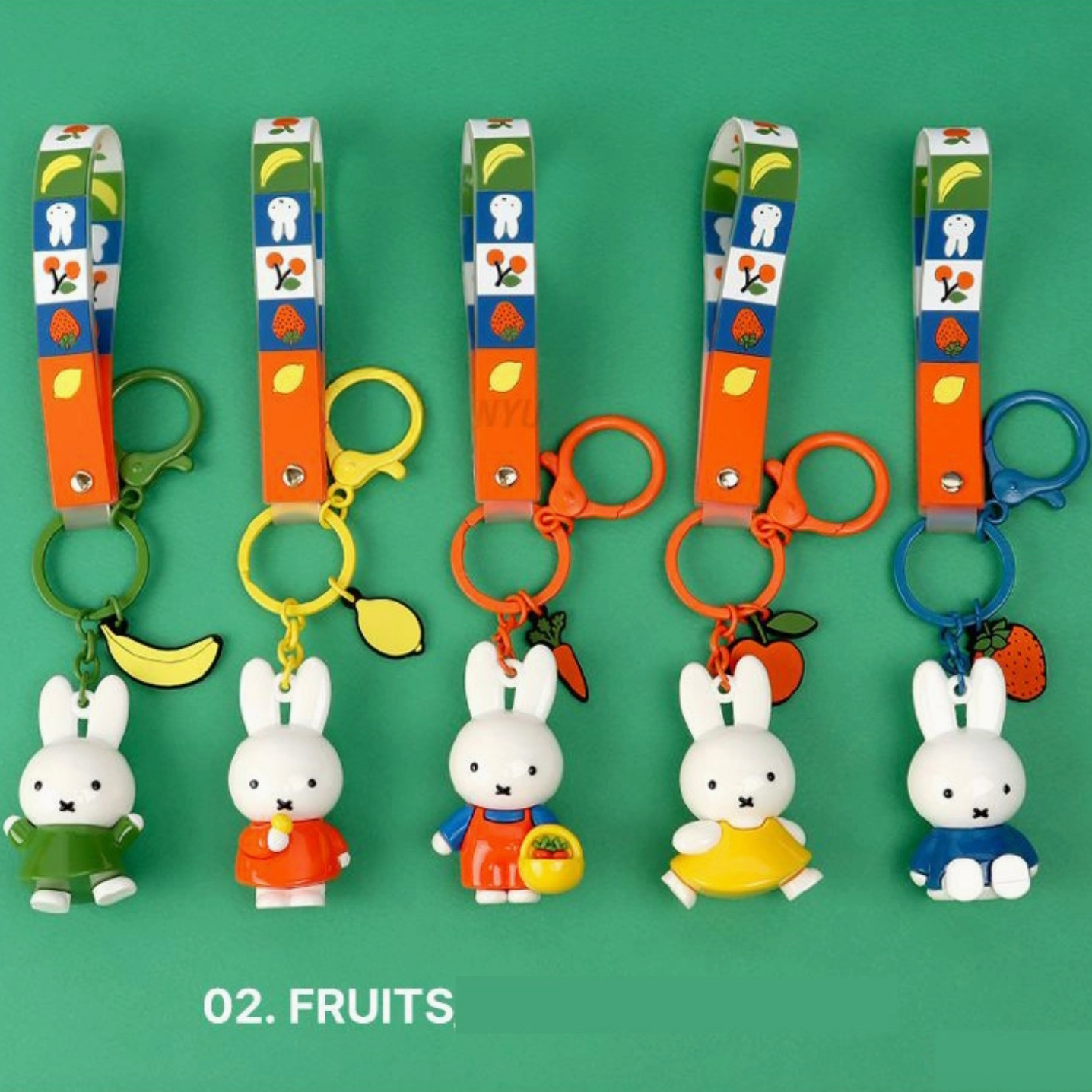 Set of keychains with cartoon characters and fruit-themed designs on a green background