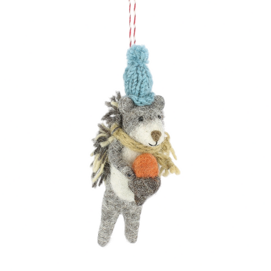 Knitted wolf ornament with a blue pom-pom hat on a white background