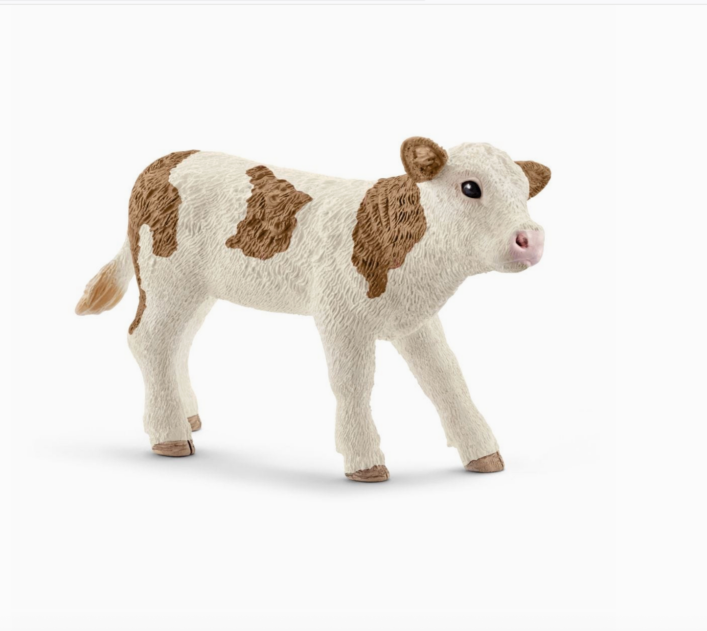 Plush toy cow with brown patches on a white background