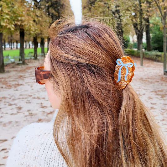Person with long hair tied back with a scrunchie in an outdoor setting