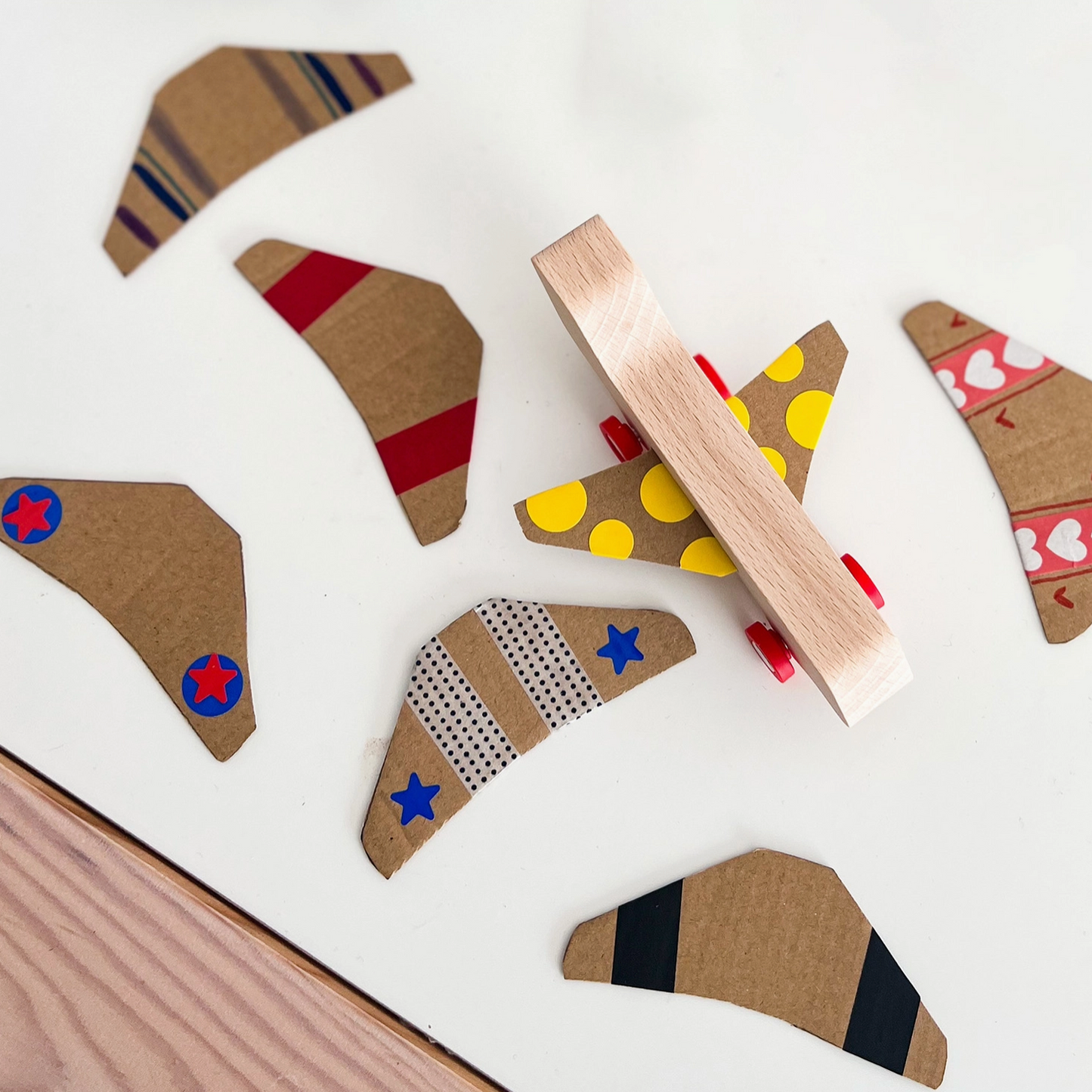 Wooden airplane toys with various patterns on a white surface