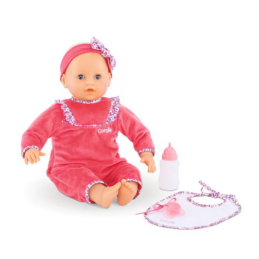 Baby doll in pink outfit with accessories on a white background