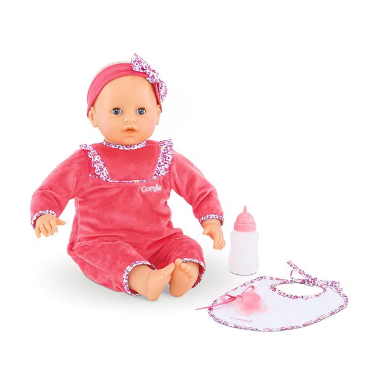 Baby doll in pink outfit with accessories on a white background