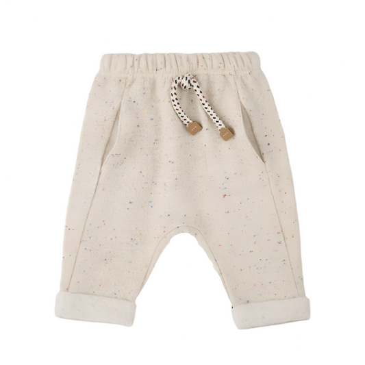 Beige baby pants with a rattle on a white background